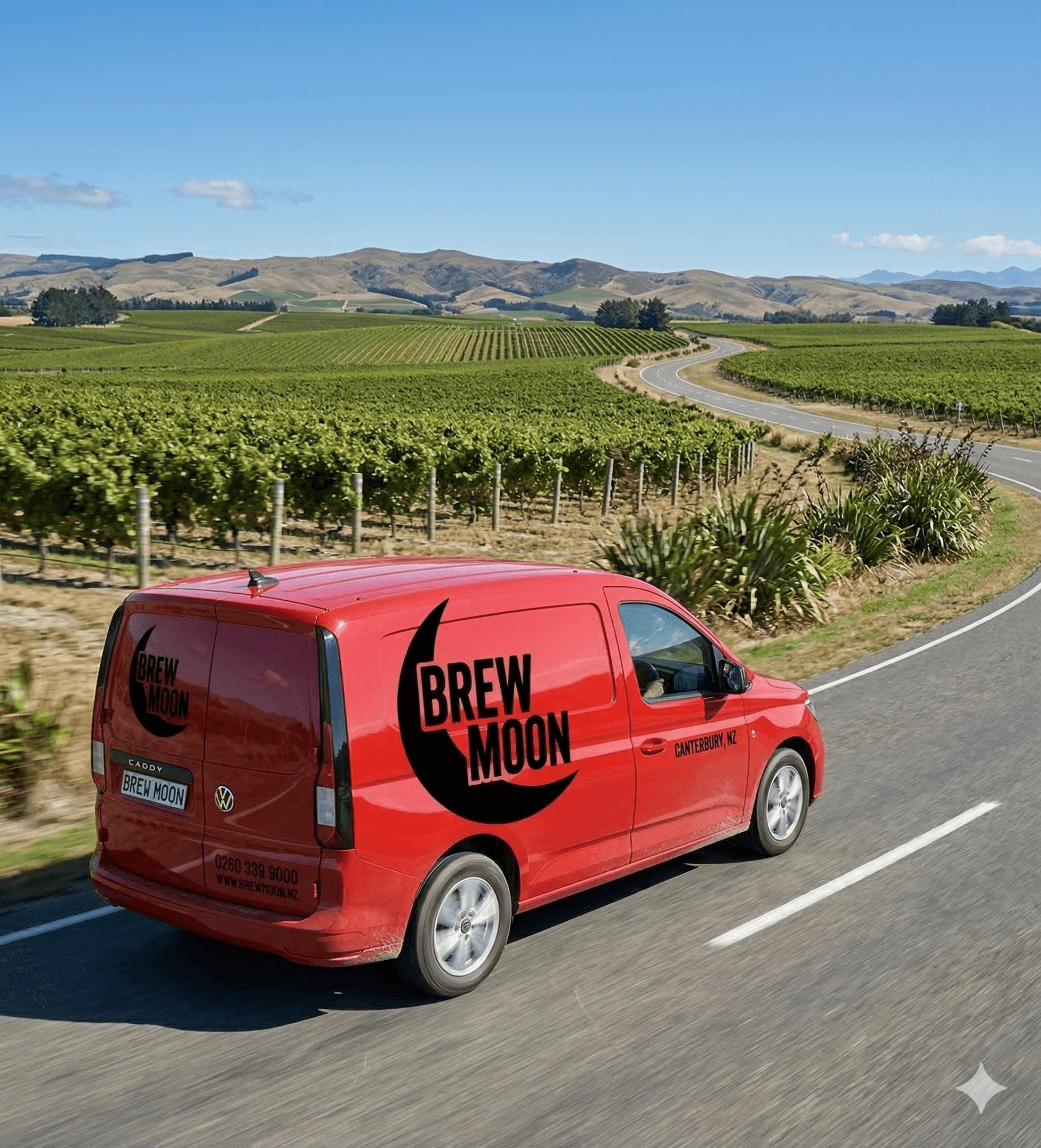 Red Brew Moon van driving along a winding road through lush green vineyards and hills.